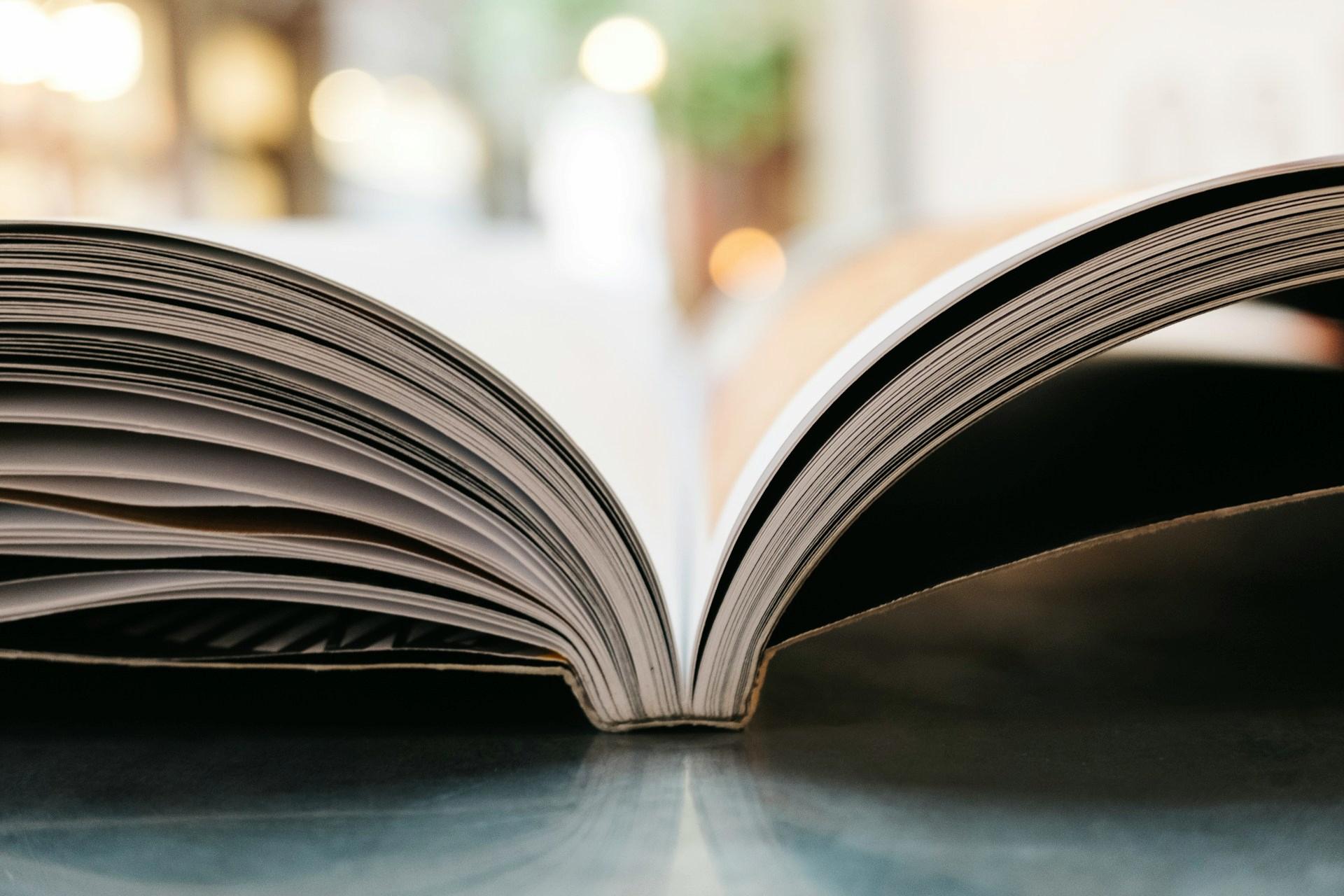 An open book rests on a reflective surface.